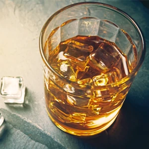 A glass of alcohol with ice cubes 