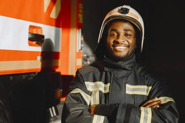 A fire fighter stands in front of a fire engine