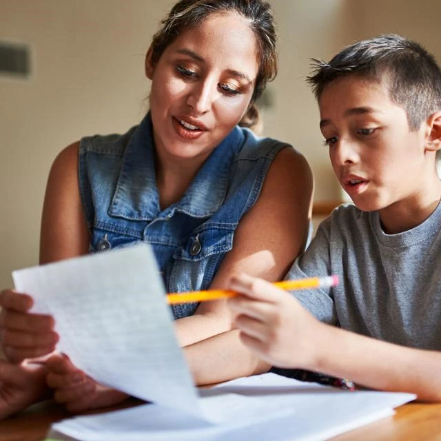 Femal adult helping a boy with homework