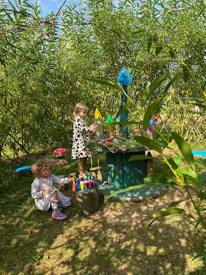 2 children playing with colourful objects in a sunny field