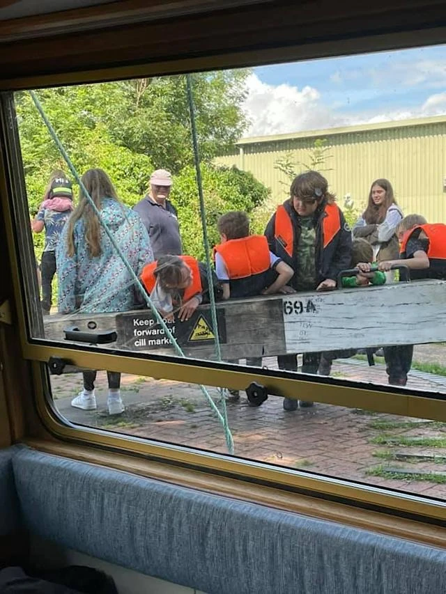 Children in life vests sailing on a canal boat on a sunny day
