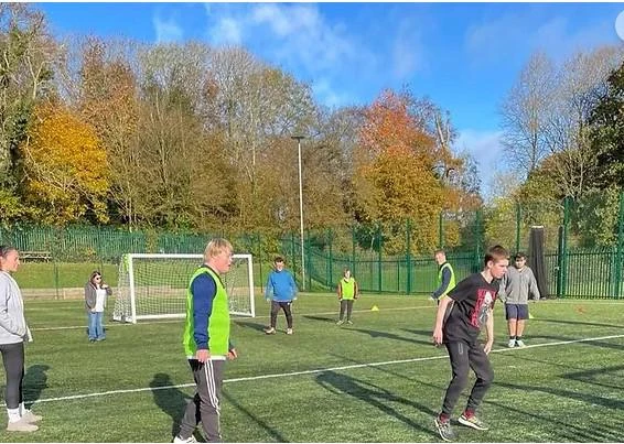 young people on astroturf pitch playing football