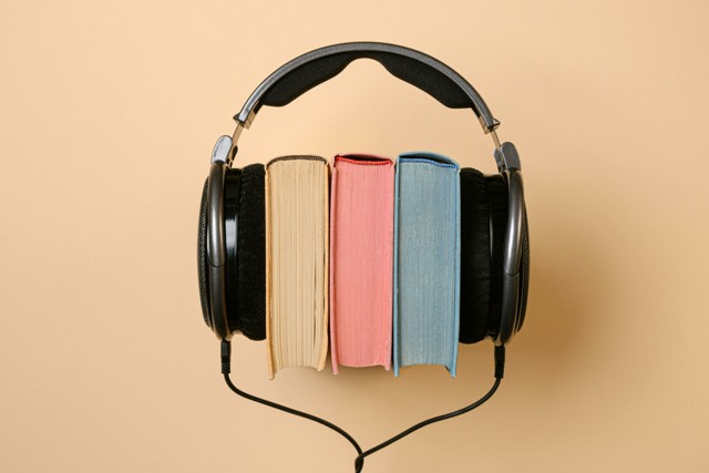 3 books nestled in a pair of headphones