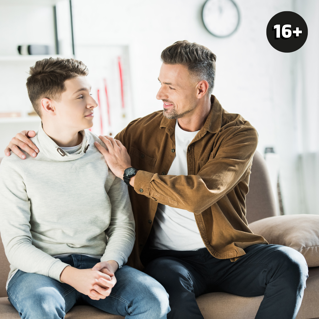 A father puts a supportive arm around his teenage son